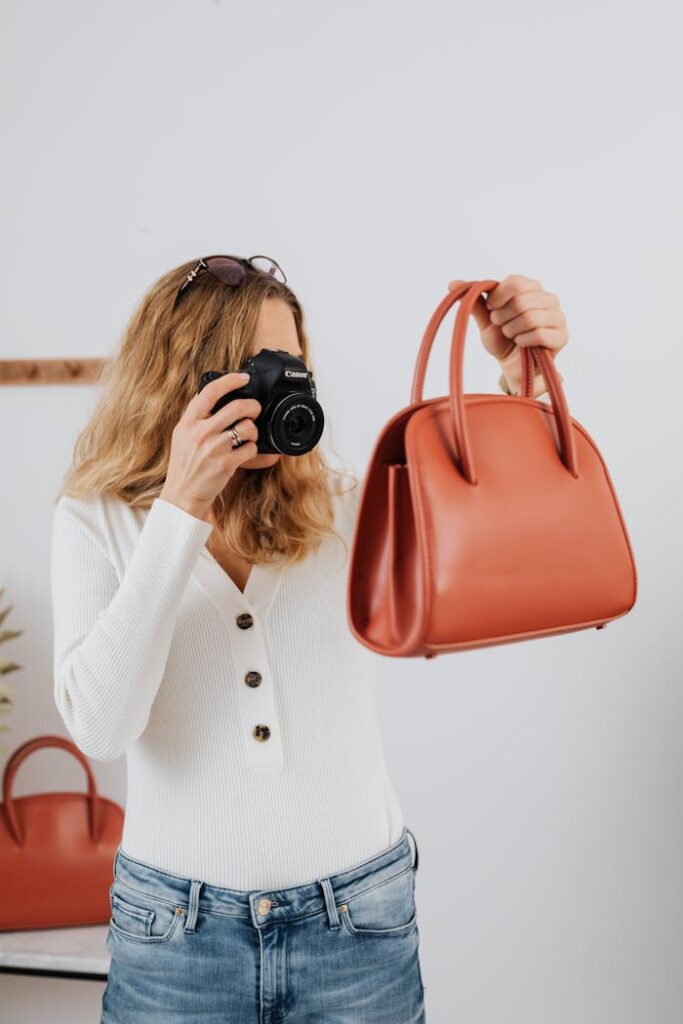 Female photographer capturing a red handbag, showcasing online selling photography techniques.